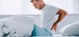Man with back pain on the mattress.