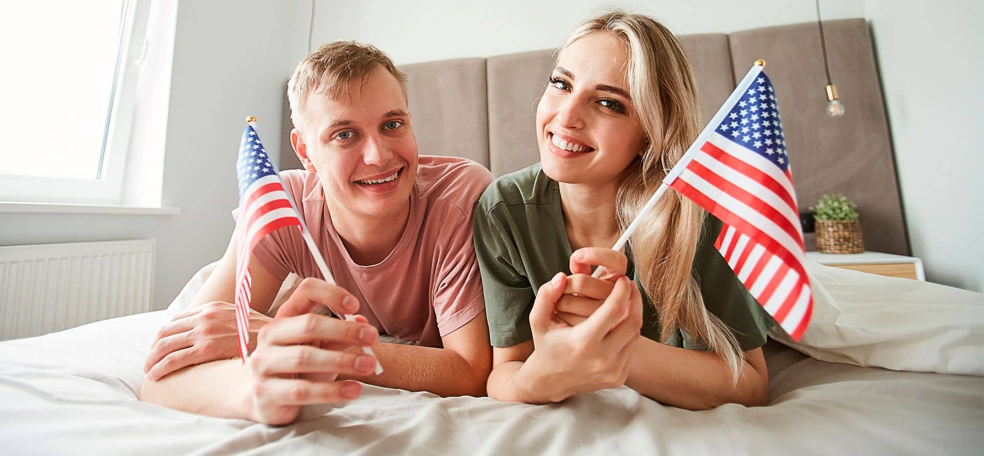 Man and woman celebrate the 4th of July on a new mattress.