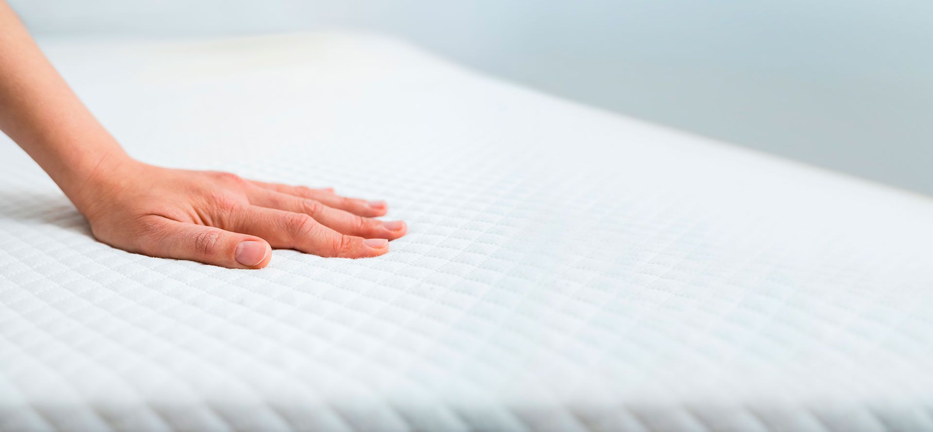 Hand on a firm mattress.