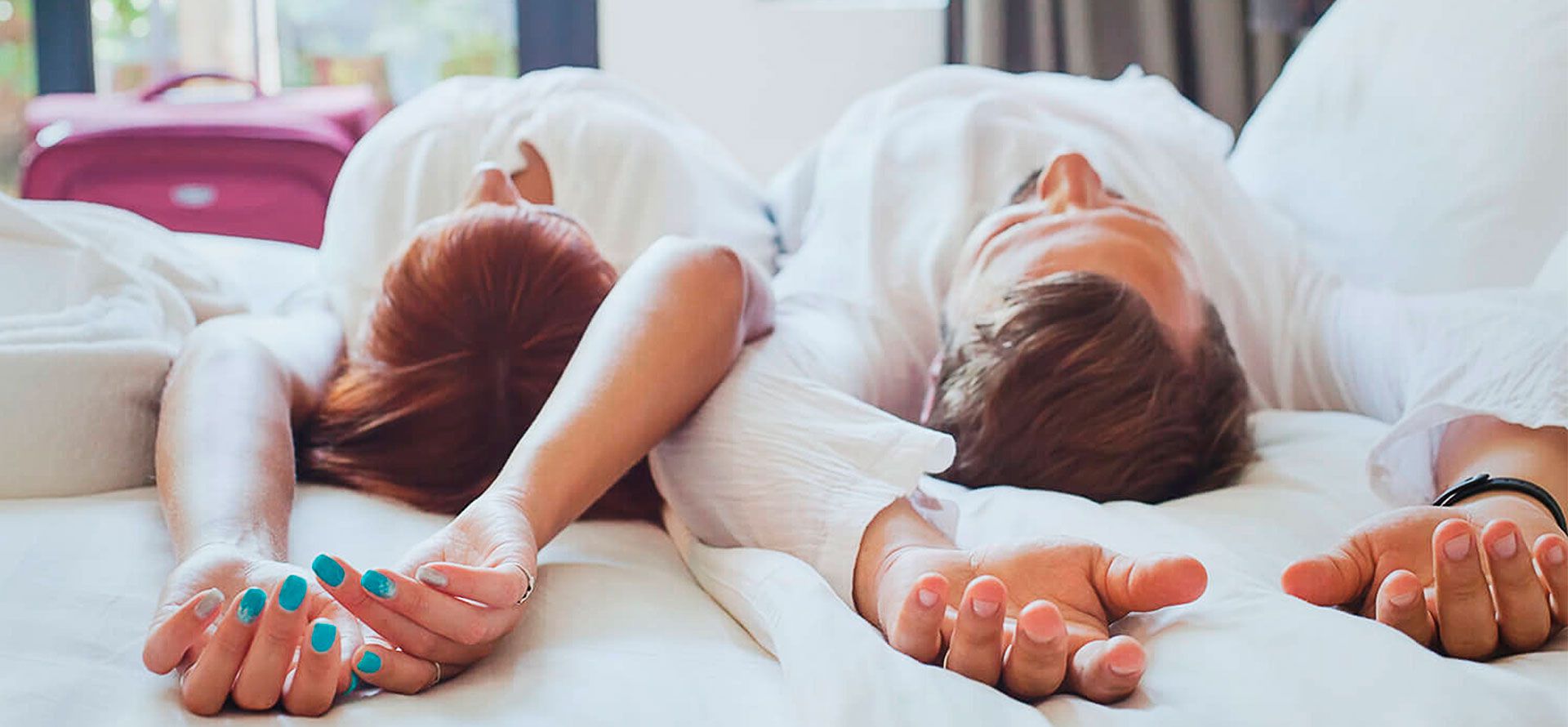 A couple lies on a mattress after a trip.