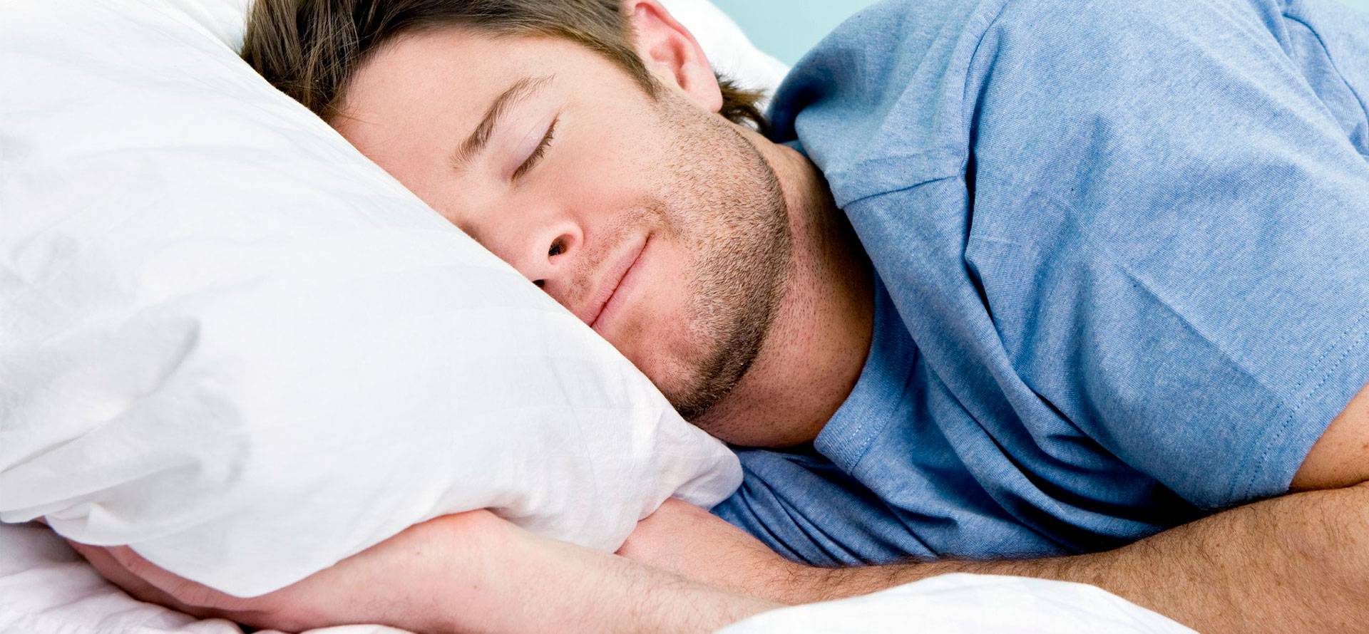 The man happily sleeps on an orthopedic mattress.