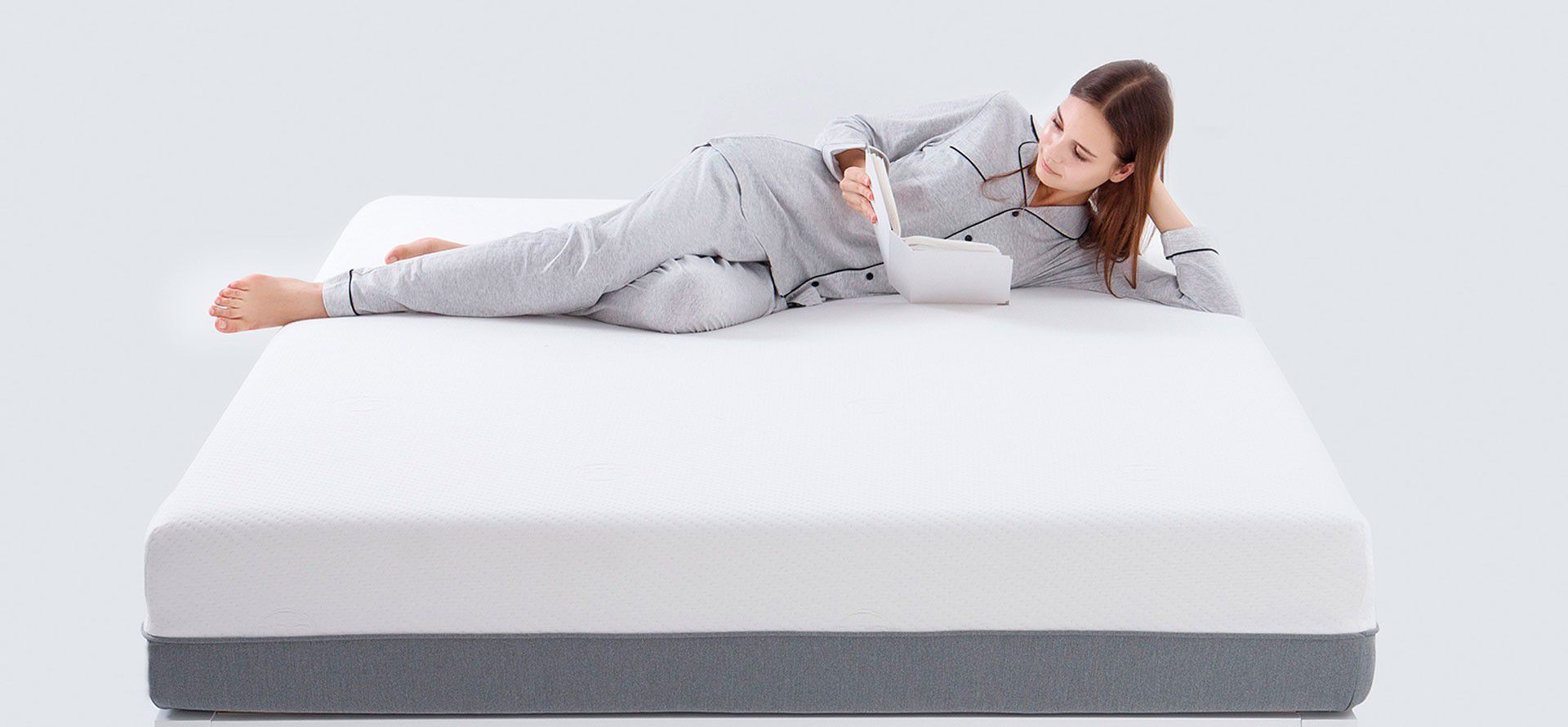 A woman lies on a mattress.