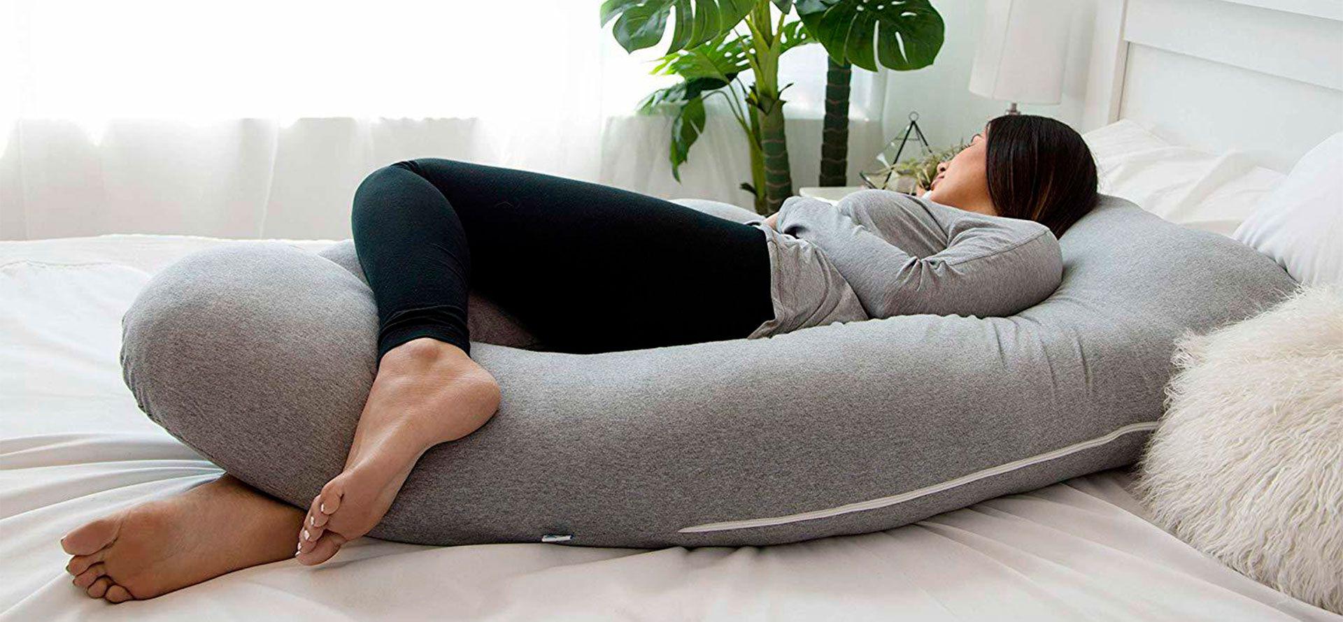 A woman sleeping with pregnancy pillow.